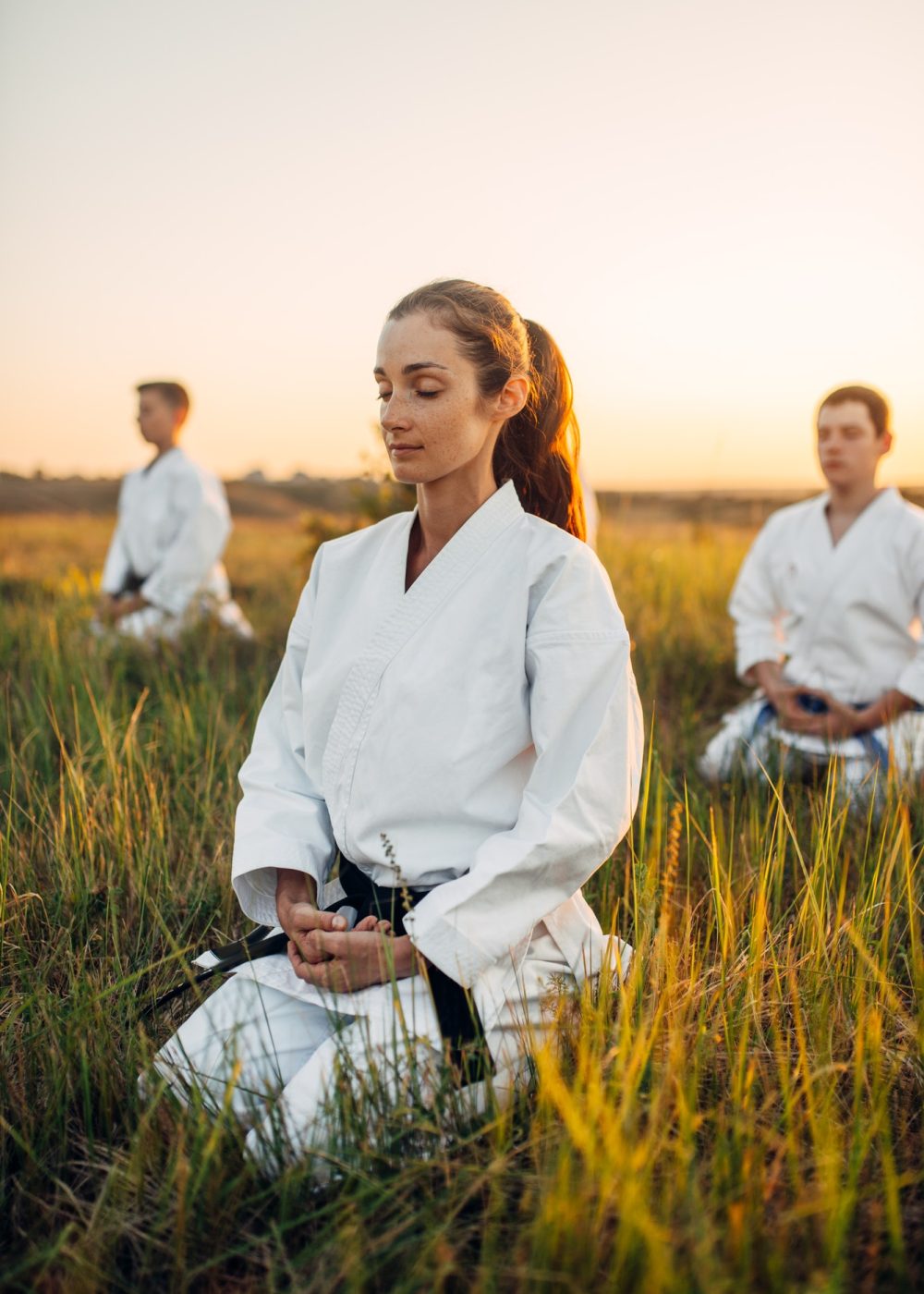 karate-class-meditates-on-training-in-summer-field.jpg